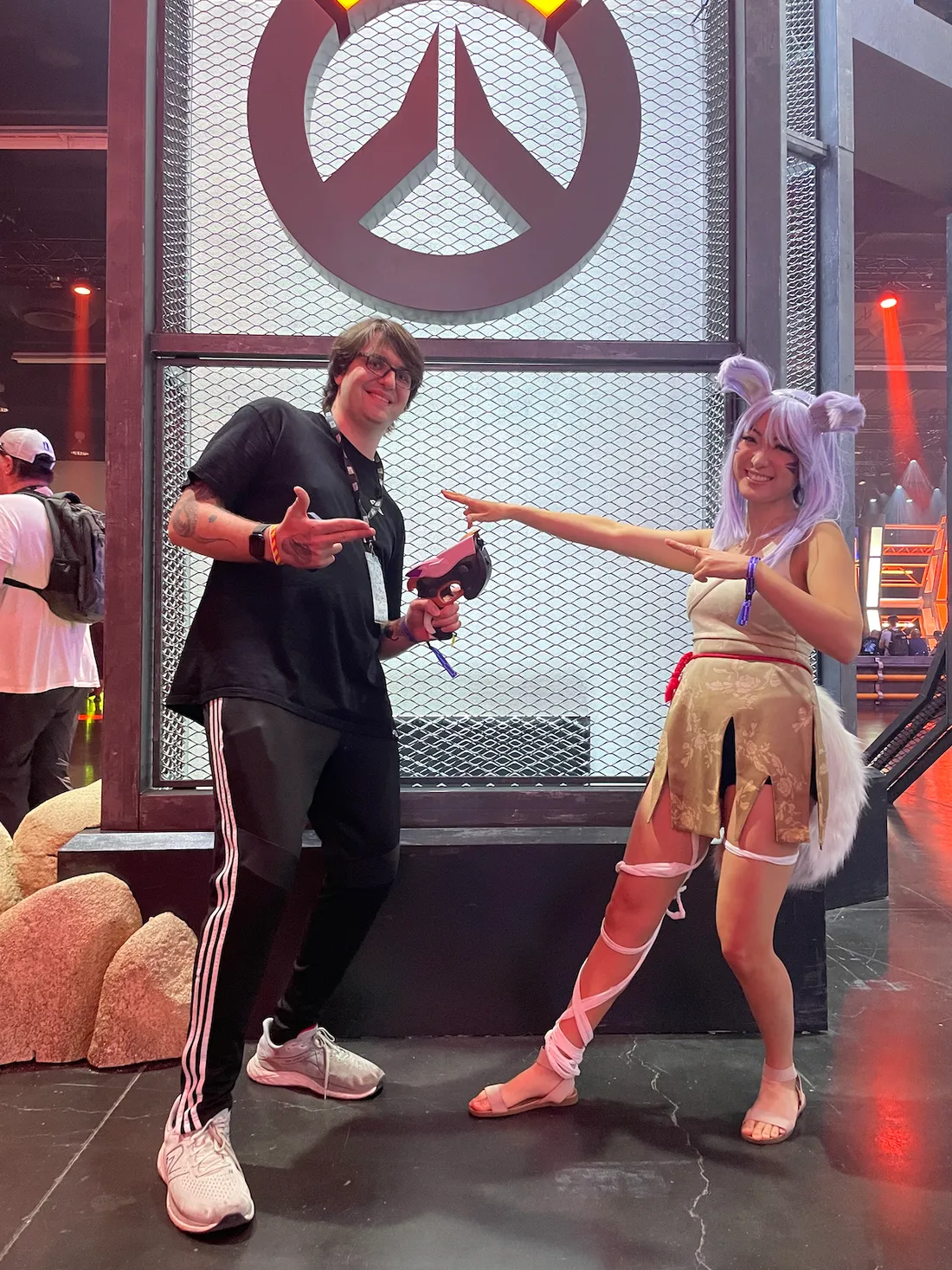 Two people pointing at one another at BlizzCon, one person is dressed as a character from Overwatch.