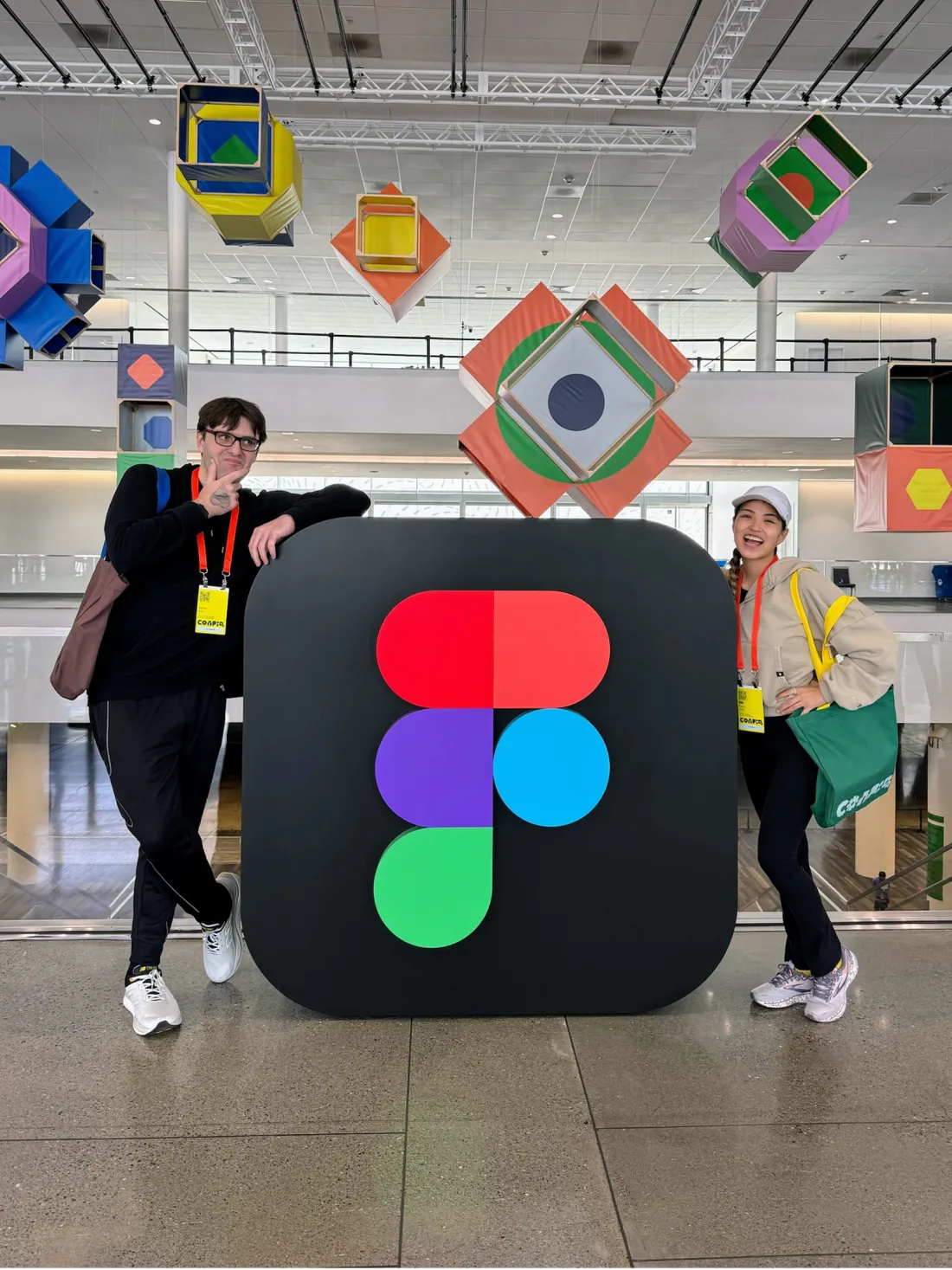 Two people standing besides the Figma logo