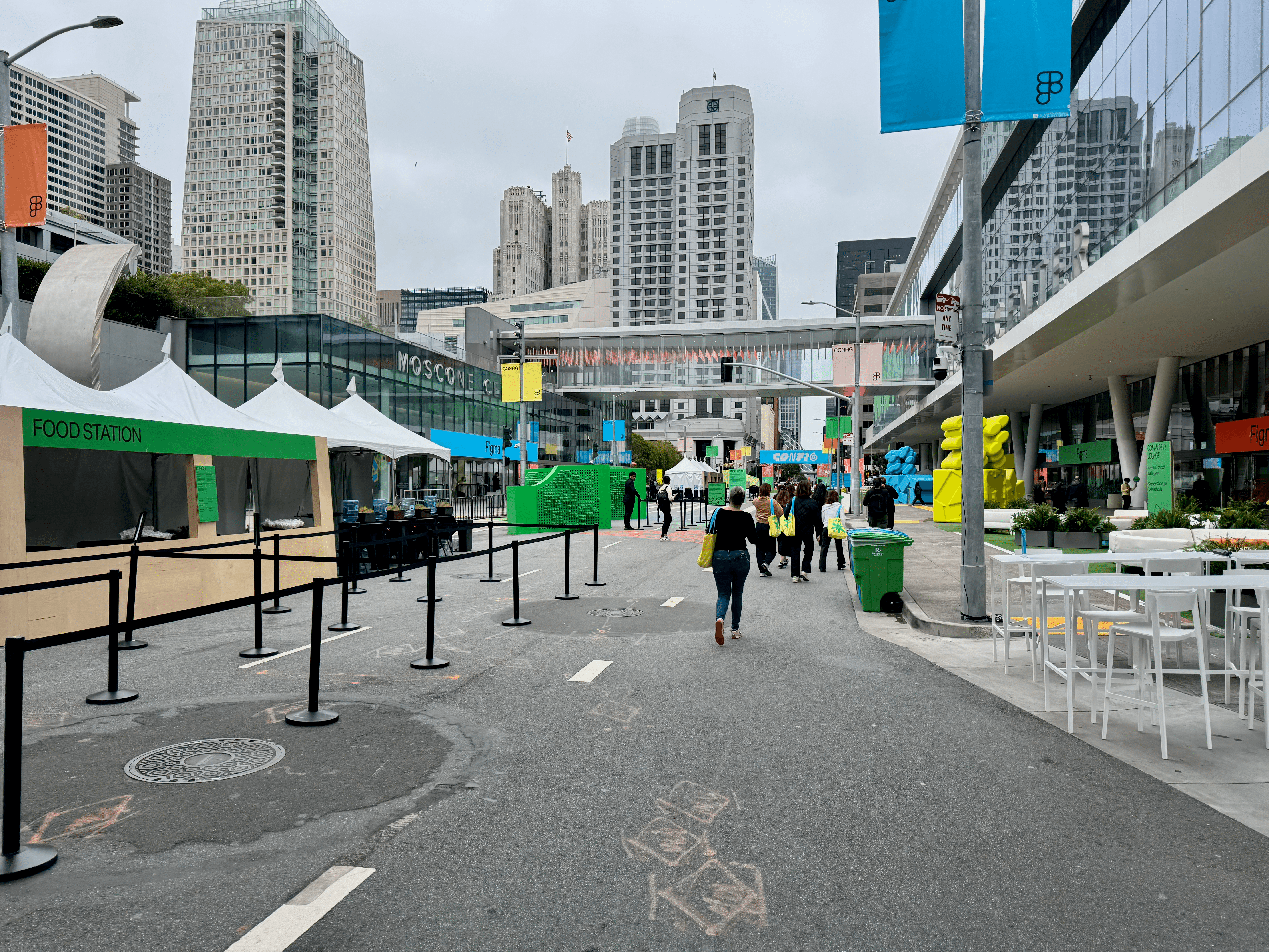 A street outside Moscone Center closed for the conference, with a food station tent, outdoor seating, and Config banners