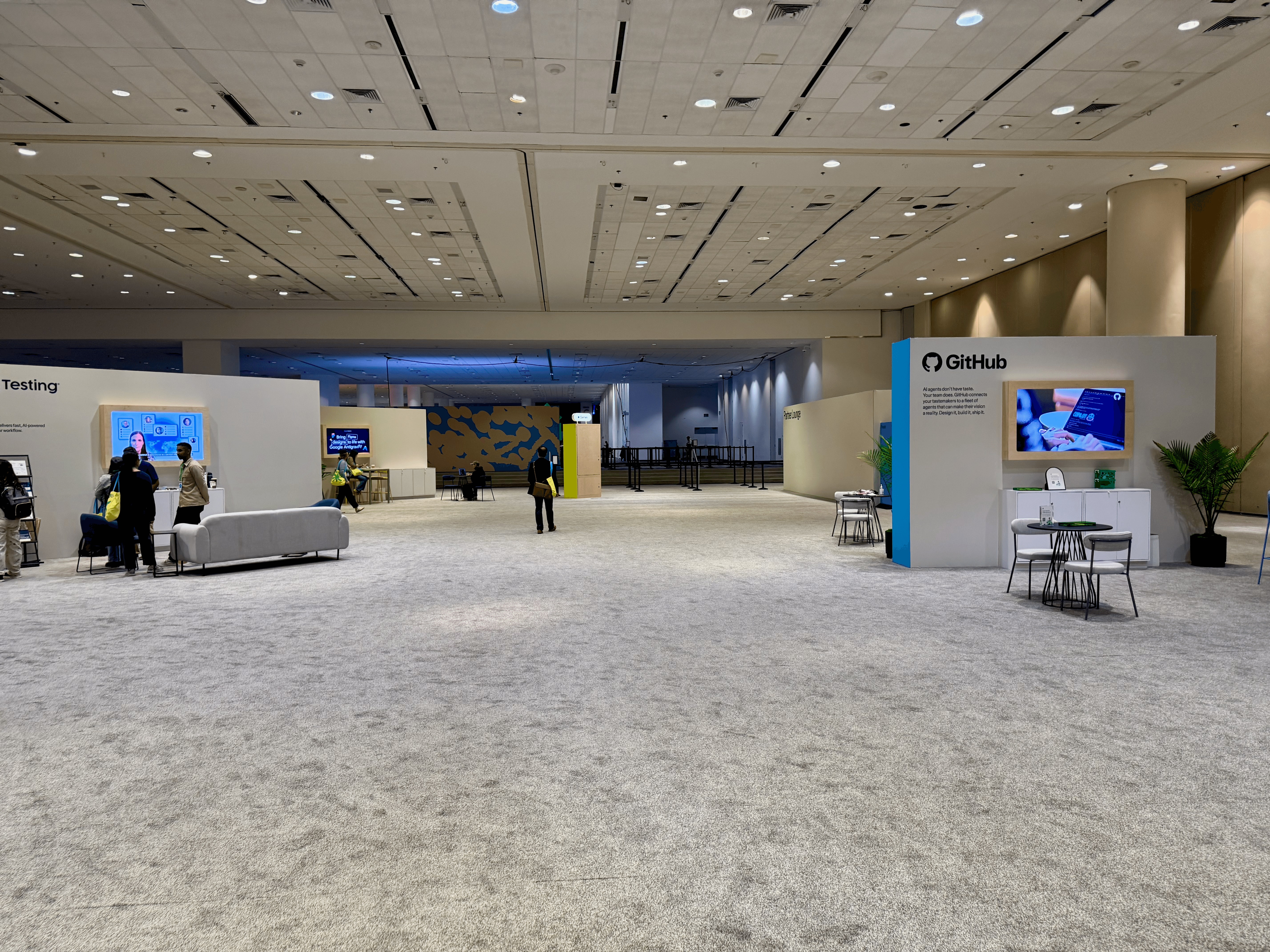 A wide view of the Config expo hall with a GitHub booth and other vendor stands set up along the sides