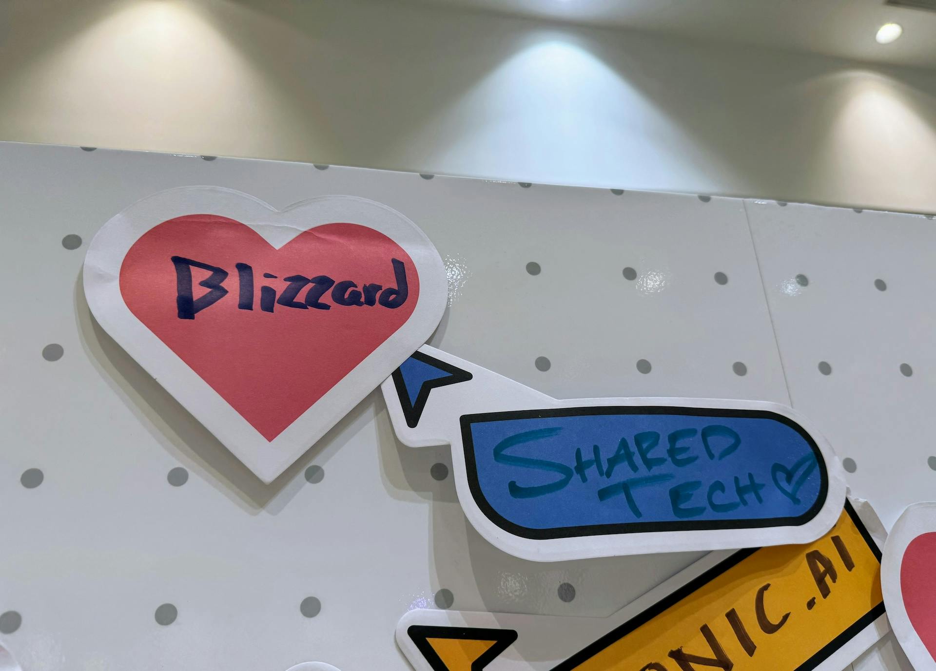 Two stickers on a board that read 'Blizzard' and 'Shared Tech'.