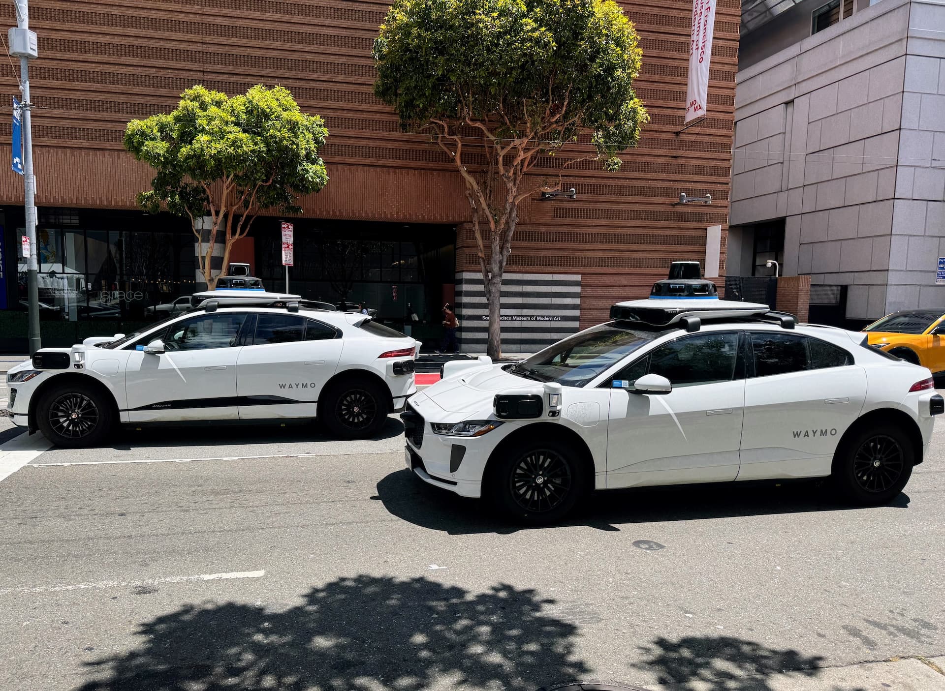 Two cars on a road with spinning sensors on top.